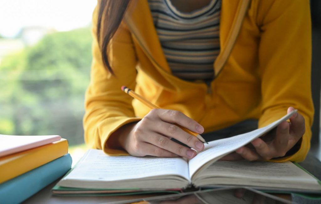 Student writing notes for Humanities Subjects